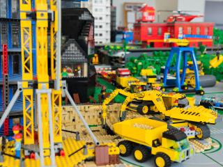 Die LEGO Baumaschinen arbeiten auf der Baustelle für einen LEGO-Wolkenkratzer